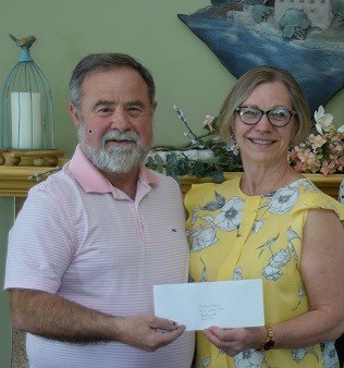 Pictured is Gerald Tracey, Hospice Renfrew Board Chair, receiving a donation from Susan Dupuis